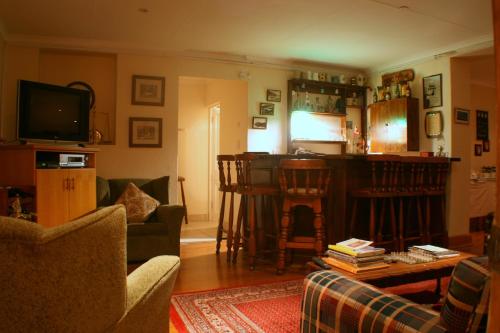 a living room with a couch and a bar at Knysna Manor House in Knysna