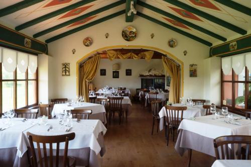 a dining room with white tables and chairs at Castello Di Spessa - Residenze d'epoca in Capriva del Friuli
