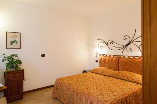 a bedroom with a bed with a orange bedspread at Colleverde Country House & SPA Urbino in Urbino