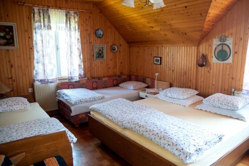 um quarto com 4 camas num quarto de madeira em Sovica em Bled