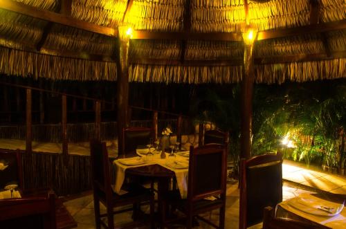 a dining room with a table and chairs and lights at Long Beach in Canoa Quebrada