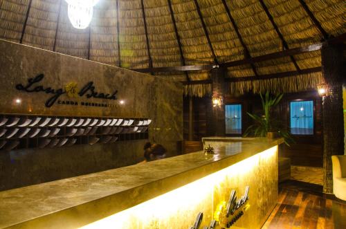 a bar in a restaurant with a straw roof at Long Beach in Canoa Quebrada