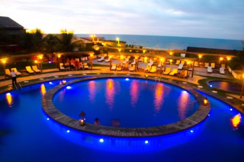 a large pool with blue lights in a resort at Long Beach in Canoa Quebrada