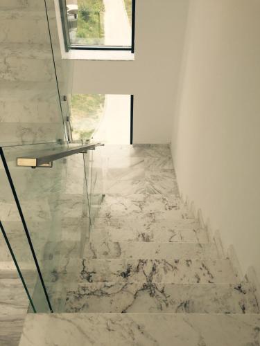 a marble floor with a glass table in a room at Mamaia Beach Side in Mamaia