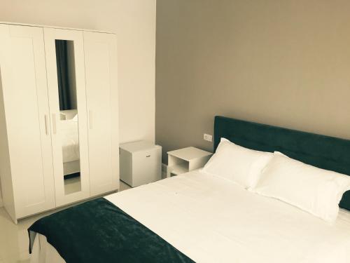 a bedroom with a bed with a green headboard and a mirror at Mamaia Beach Side in Mamaia