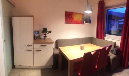 a small living room with a table and a cabinet at Appartement Schusternagele in Amlach