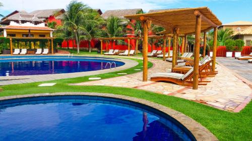 a swimming pool with a gazebo and a resort at Long Beach in Canoa Quebrada