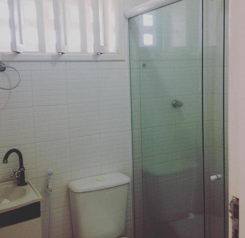 a bathroom with a toilet and a glass shower at CHALÉS ENCANTOS DA ILHA in Barra dos Coqueiros