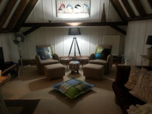 a living room with two chairs and a table at B & B De Pimpelmees in 's-Gravenmoer