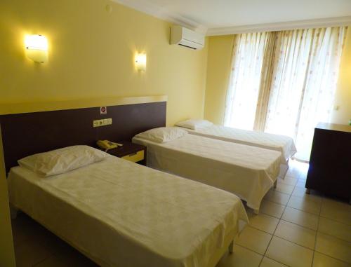 a hotel room with two beds and a window at Hotel Kleopatra in Alanya