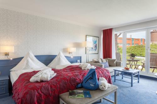 a hotel room with a bed with stuffed animals on it at Hotel Pabst in Juist