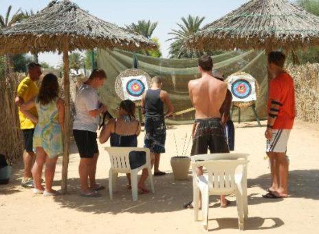 a group of people standing under a umbrella on the beach at Zephir Hôtel & Spa in Zarzis