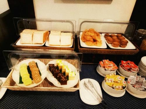 a table topped with trays of different types of food at Viang Thapae Resort in Chiang Mai