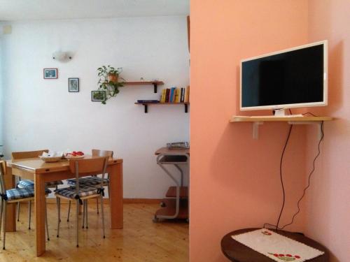 a room with a table and a tv on a wall at Le Betulle in Vezzano