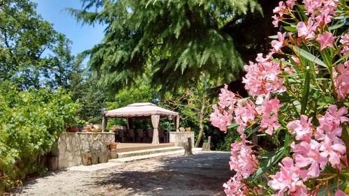 a gazebo in a park with pink flowers at Il Querceto in Bosco