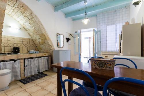 una cucina con tavolo in legno e sedie blu di la casa di Daisy a Carloforte
