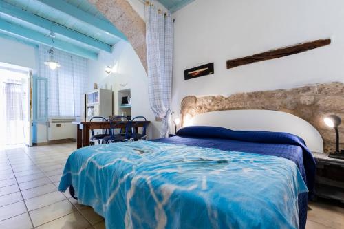 a bedroom with a large bed with a blue blanket at la casa di Daisy in Carloforte