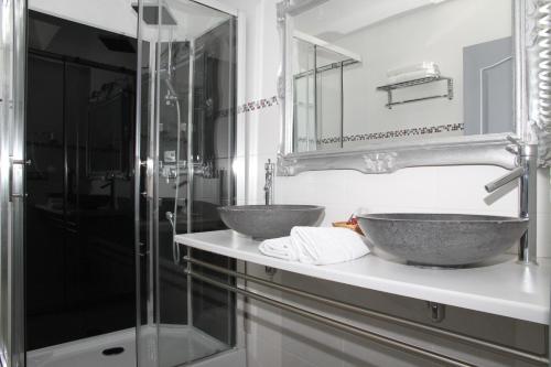 a bathroom with two sinks and a shower at Hotel Saint Germain in Pézenas