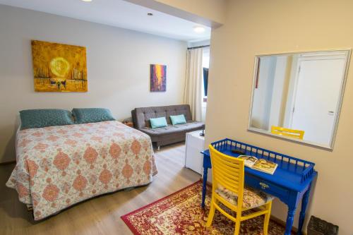 a bedroom with a bed and a table and a mirror at Hospedaria Conceitual in Florianópolis