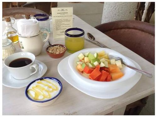 a table with a plate of fruit and a cup of coffee at HEVEN Residence in Zipolite