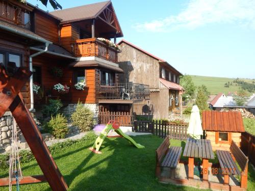 une cour avec une aire de jeux en face d'une maison dans l'établissement Apartmán Lukáš, à Ždiar