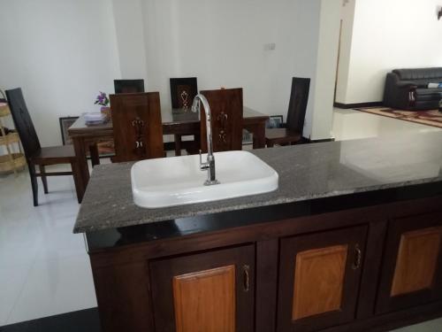a kitchen counter with a sink and a table at Hill House Rest in Mirissa