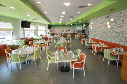 a dining room with tables and chairs in a restaurant at CHN Hotel Monterrey Norte, Trademark Collection by Wyndham in Monterrey