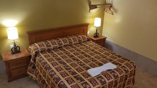 a bedroom with a bed with two lamps on both sides at Luxury Inn in Absecon