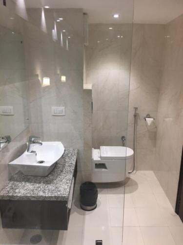 a bathroom with a sink and a toilet and a shower at Shiva Oasis Resort in Neemrana