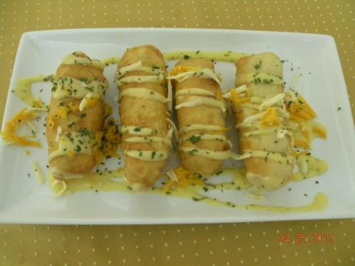 a white plate of food with cheese and rolls at The Red Hut Inn in Belize City