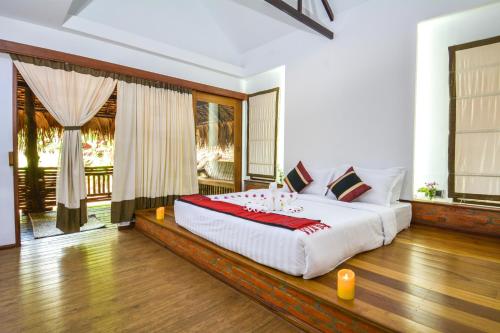 ein Schlafzimmer mit einem großen Bett in einem Zimmer in der Unterkunft Hotel Queen Jamadevi in Mawlamyaing