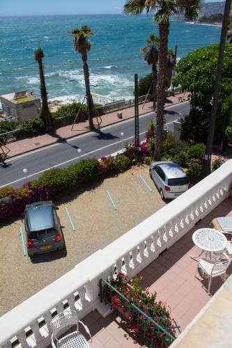 a balcony with a car parked next to the ocean at Hotel Villa La Brise in Sanremo