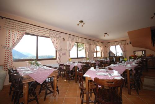 a dining room with tables and chairs and windows at Georgio's V Chalet Kalavrita in Kalavrita