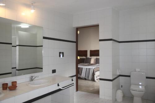 1 dormitorio y baño con lavabo y aseo. en B&B Casa Hernández en San Lorenzo