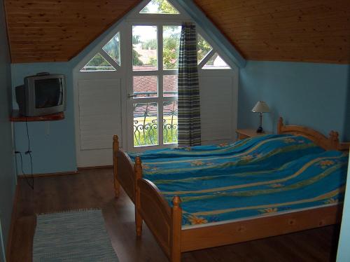 a bedroom with a bed and a tv and a window at Apartmanház Sipos Siófok in Siófok