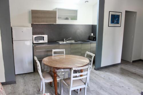 a kitchen with a table and chairs in a kitchen at LES OISEAUX (L'HIRONDELLE) in Rouen