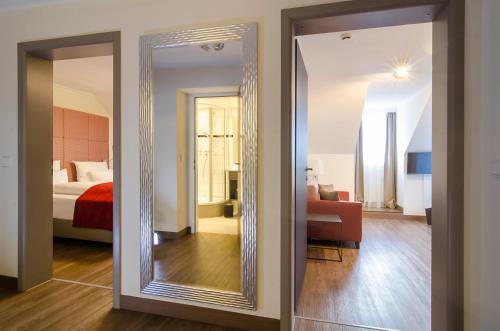 a large mirror in a room with a bedroom at Gasthof Goldener Fisch in Lienz