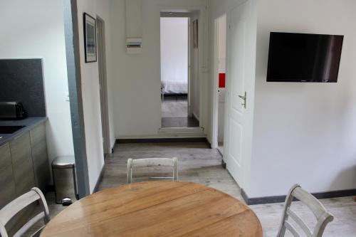 a dining room with a table and chairs and a hallway at LES OISEAUX (L'HIRONDELLE) in Rouen