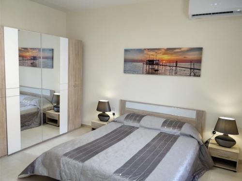 a bedroom with a large bed and two lamps at SunStone Court in St Paul's Bay