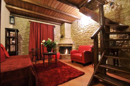 a bedroom with a living room with a fireplace at Georgio's V Chalet Kalavrita in Kalavrita