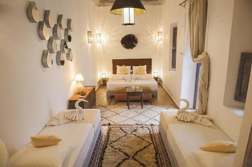 a hotel room with two beds and a bedroom at Riad De Vinci & SPA in Marrakech