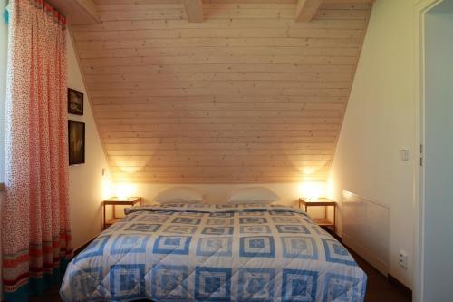 Schlafzimmer mit einem Bett mit Holzdecke in der Unterkunft Rekreační vilka Zlenice in Zlenice 