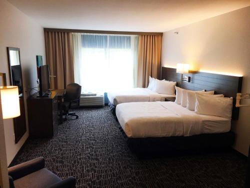 a hotel room with two beds and a window at Gundersen Hotel & Suites in La Crosse