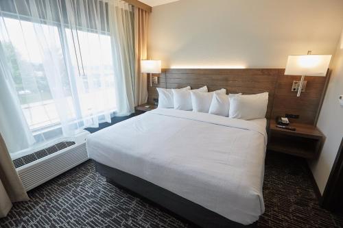 a hotel room with a large bed and a large window at Gundersen Hotel & Suites in La Crosse
