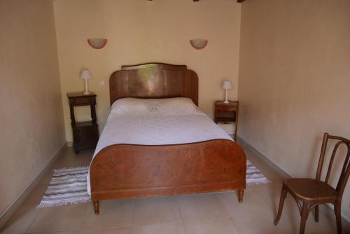 una camera con letto in legno e sedia di A Cittadella a Vico
