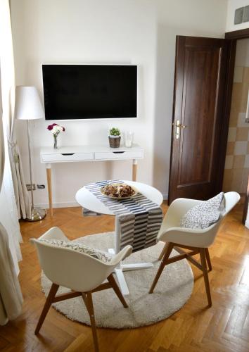 a living room with two chairs and a tv at Domus Duomo in Florence