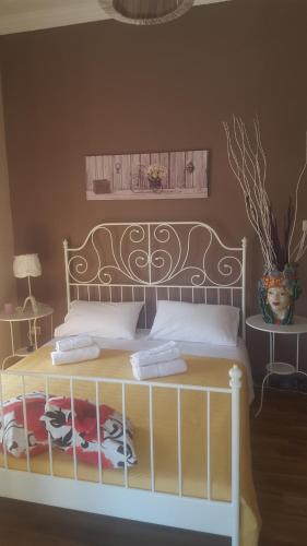 カターニアにあるSicily Home Centerのベッドルーム1室(ベッド1台、ヘッドボード、花瓶付)