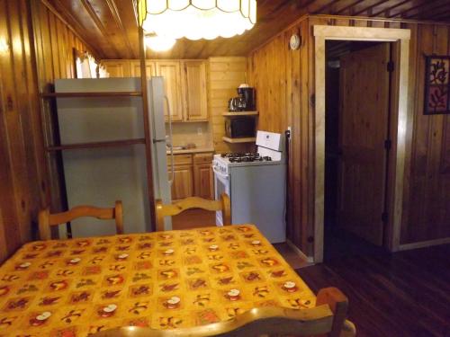a kitchen with a table and a stove and a refrigerator at Arizona Mountain Inn & Cabins in Flagstaff
