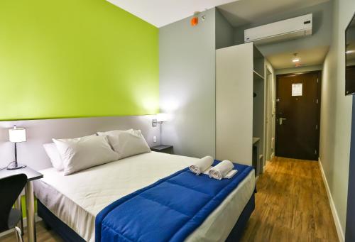 a bedroom with a bed with blue and green walls at Go Inn Santo André in Santo André