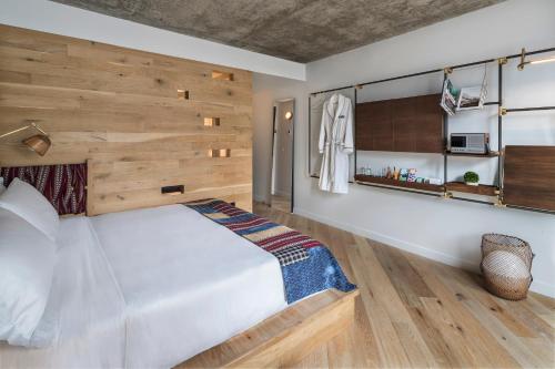 a bedroom with a large bed with a wooden wall at MADE Hotel in New York